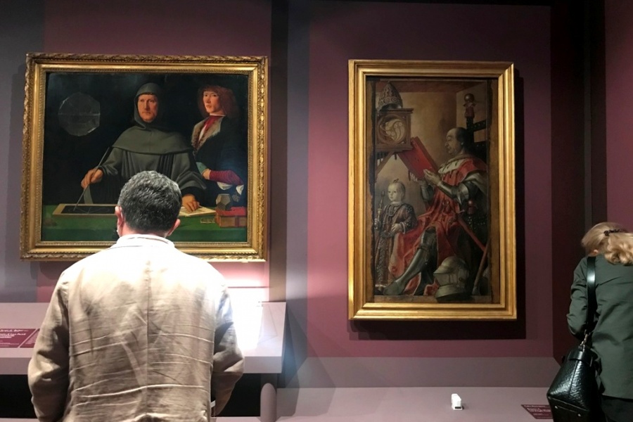 Visitatori in mostra ammirano il "Ritratto di fra Luca Pacioli con un allievo" e il "Ritratto di Federico da Montefeltro col figlio Guidubaldo".